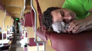 帅哥和玩具泰迪熊睡在火车上。 劳累的工人学生下班后睡觉，<strong>辛苦</strong>的一天，温柔